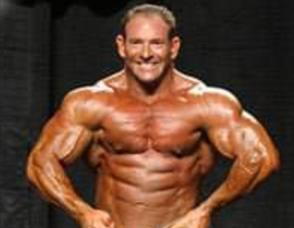 Todd Mendelsohn on stage in a front lat spread during a bodybuilding competition